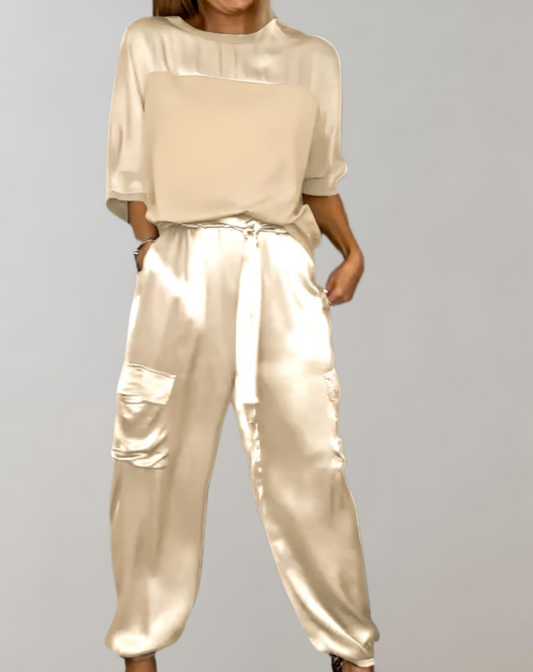 A woman wearing a silky-finish cargo top and trousers lounge set with pockets.