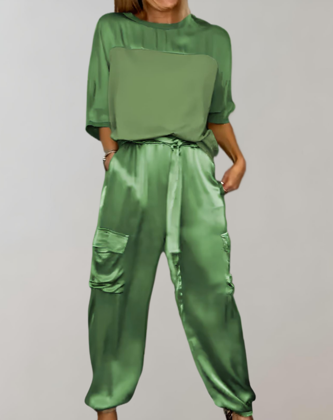 A woman wearing a silky-finish cargo top and trousers lounge set with pockets.