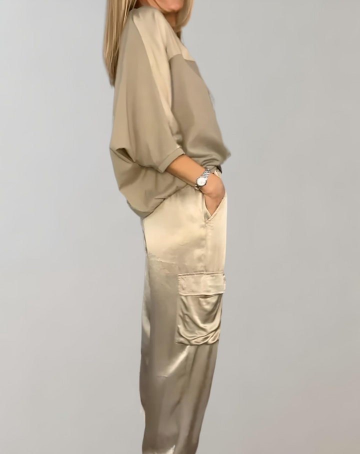 A woman wearing a silky-finish cargo top and trousers lounge set with pockets.