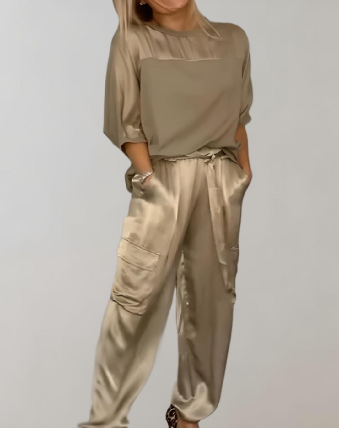 A woman wearing a silky-finish cargo top and trousers lounge set with pockets.