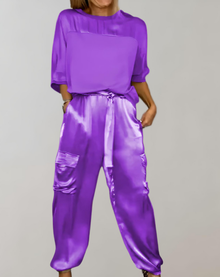 A woman wearing a silky-finish cargo top and trousers lounge set with pockets.