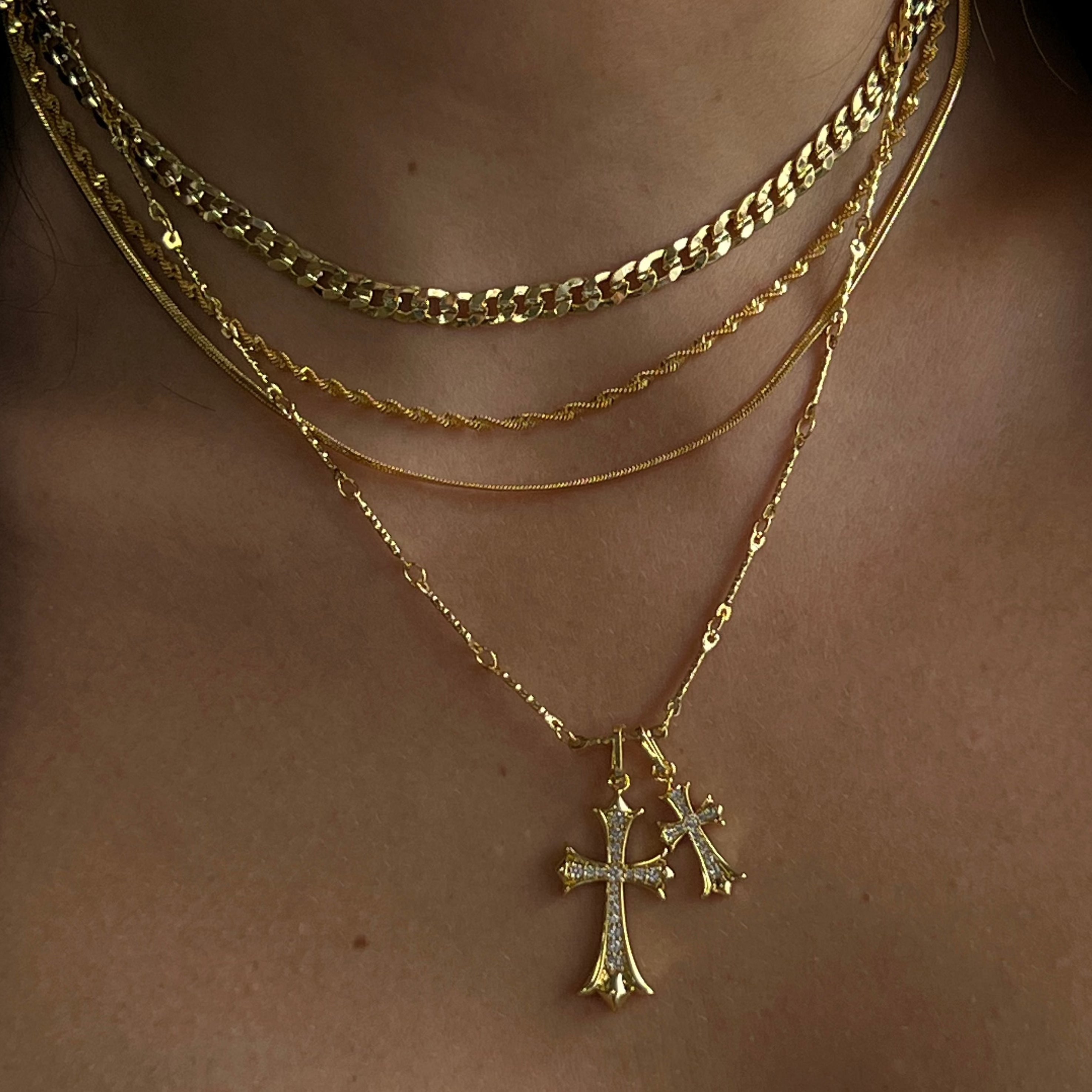 Double helix pendant necklace in gold tone on a plain white background