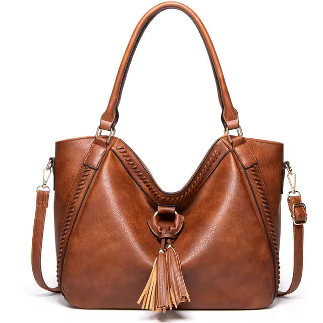 A woman carrying a soft pouch bag on her shoulder while out for a walk in town.