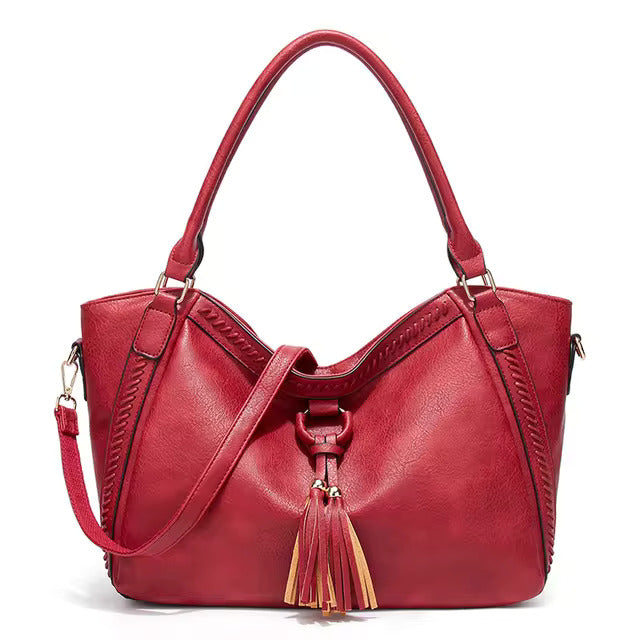 A woman carrying a soft pouch bag on her shoulder while out for a walk in town.