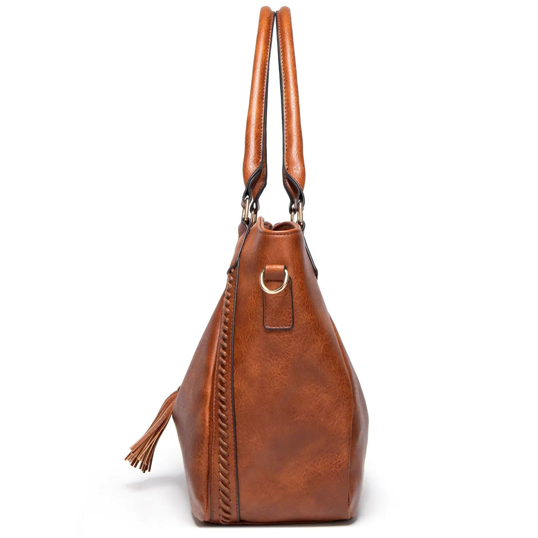 A woman carrying a soft pouch bag on her shoulder while out for a walk in town.