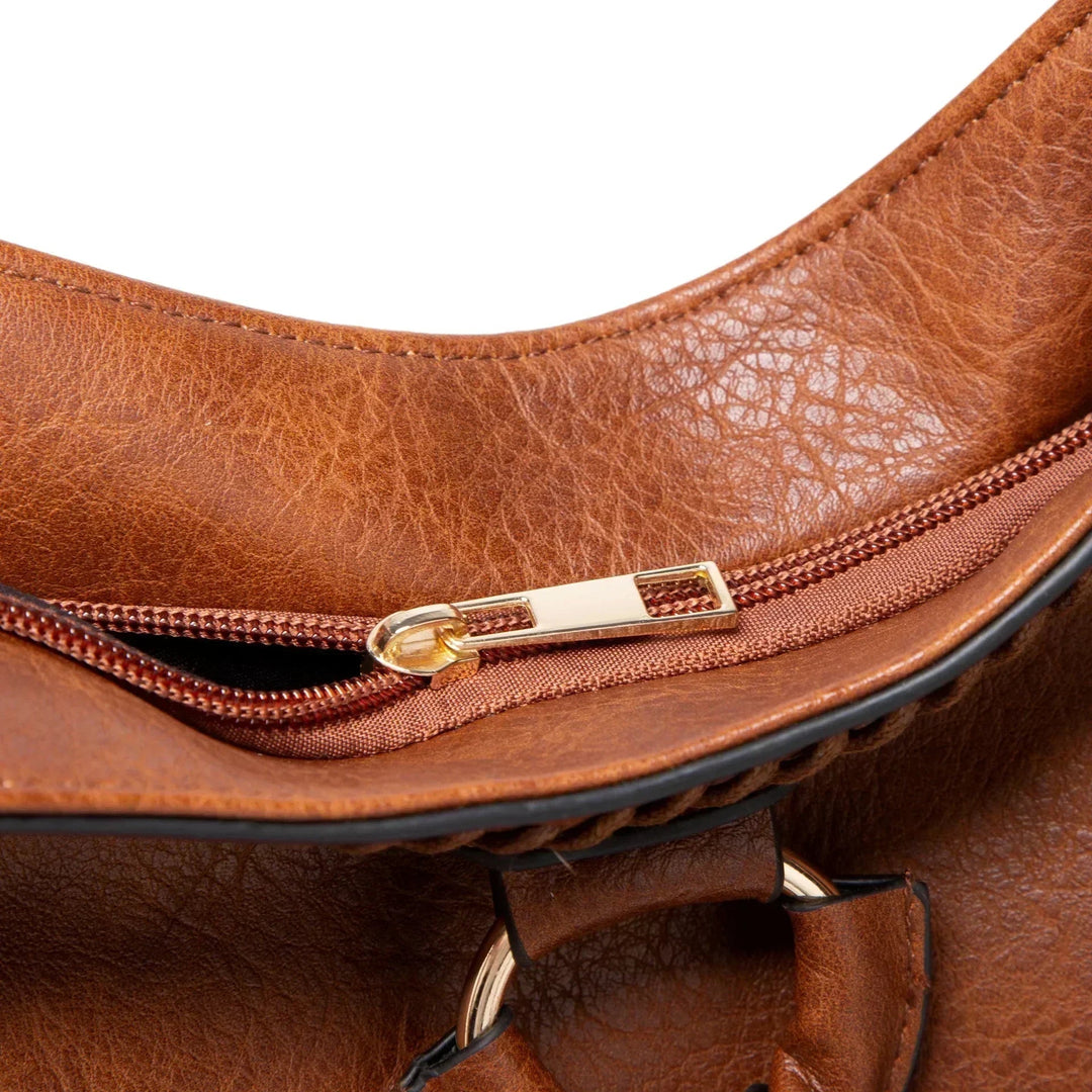 A woman carrying a soft pouch bag on her shoulder while out for a walk in town.