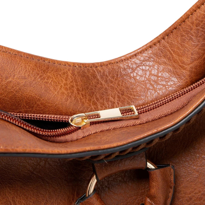 A woman carrying a soft pouch bag on her shoulder while out for a walk in town.