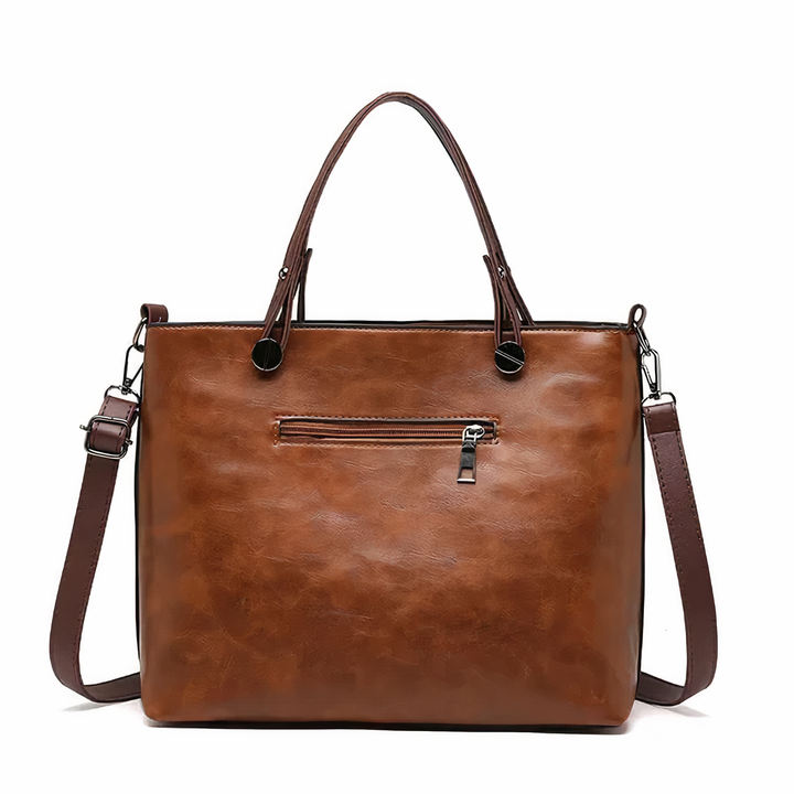 A woman holding a versatile classic handbag with a rich finish by her side