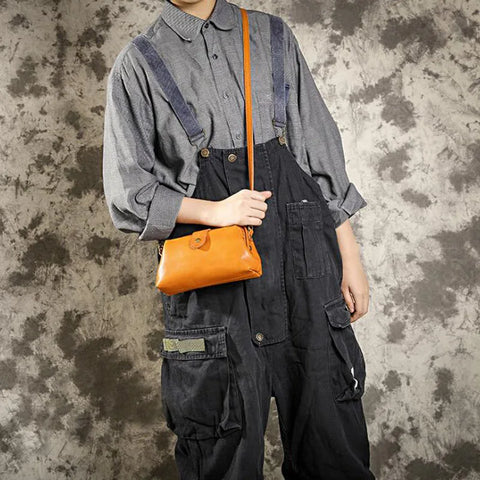 A woman carrying a trendy shoulder bag with a rich finish over one shoulder