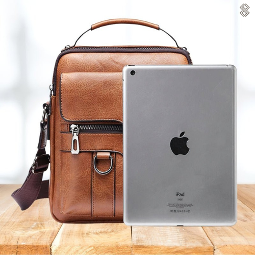 A woman carrying a roomy light brown practical handbag on her shoulder during a busy day out.