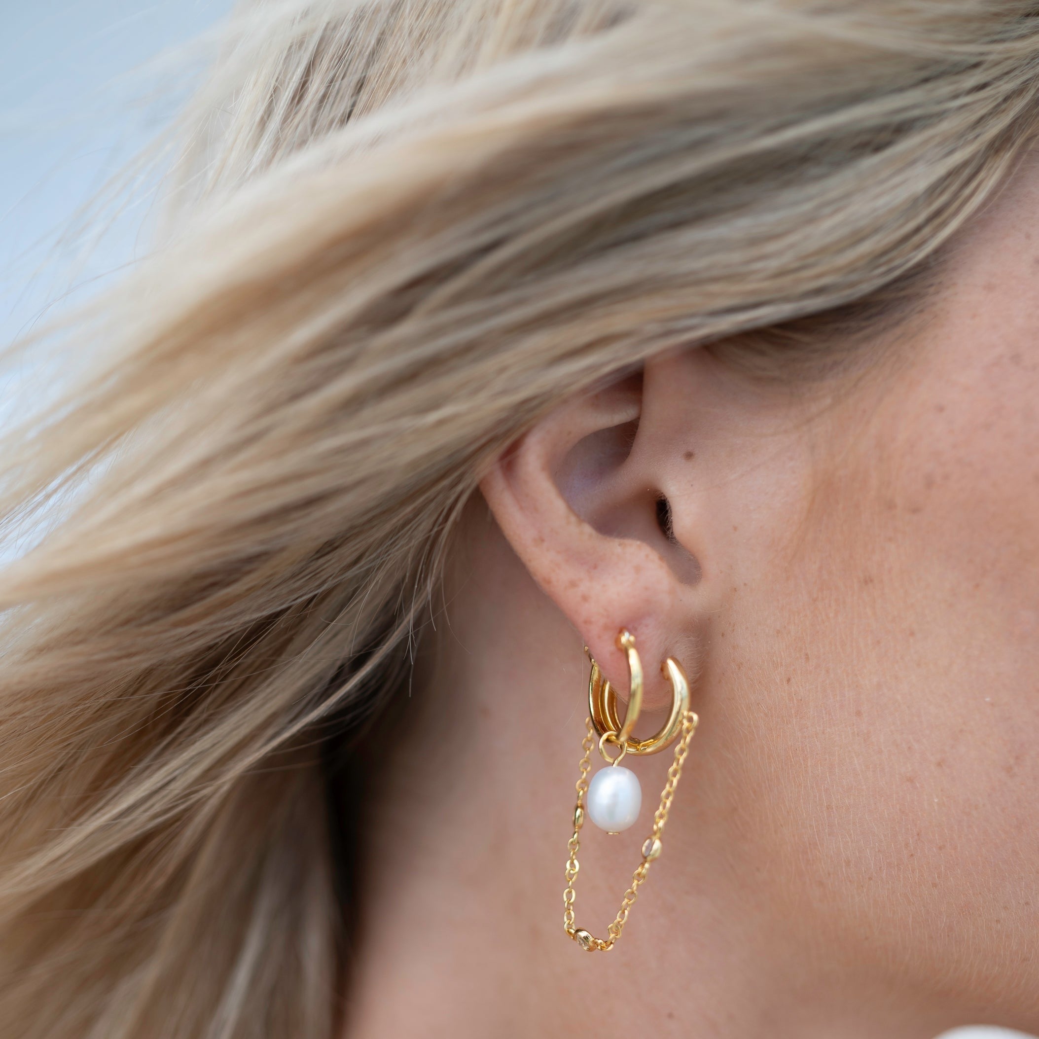 Gold sun pendant drop earrings with polished finish