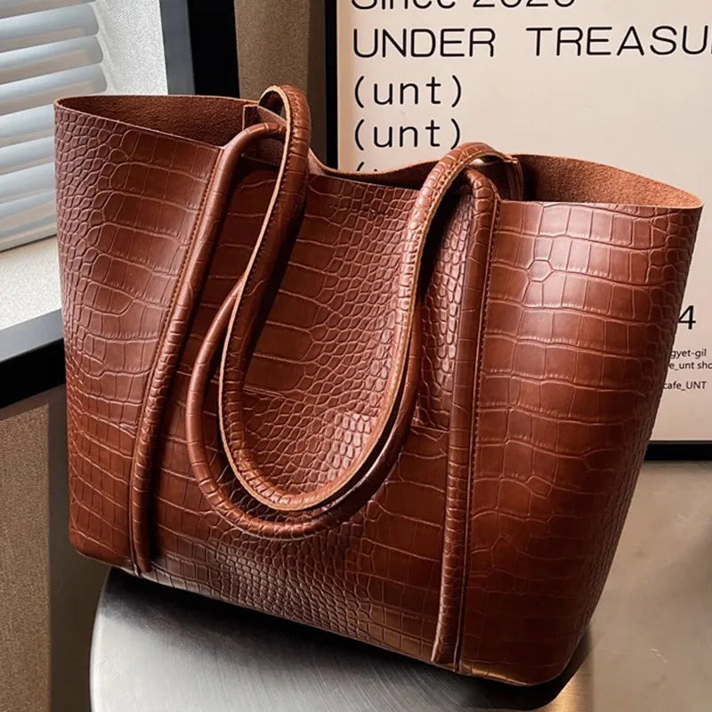 A woman carrying an elegant shoulder bag with a rich finish over one shoulder