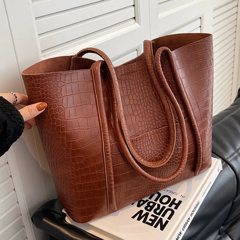A woman carrying an elegant shoulder bag with a rich finish over one shoulder