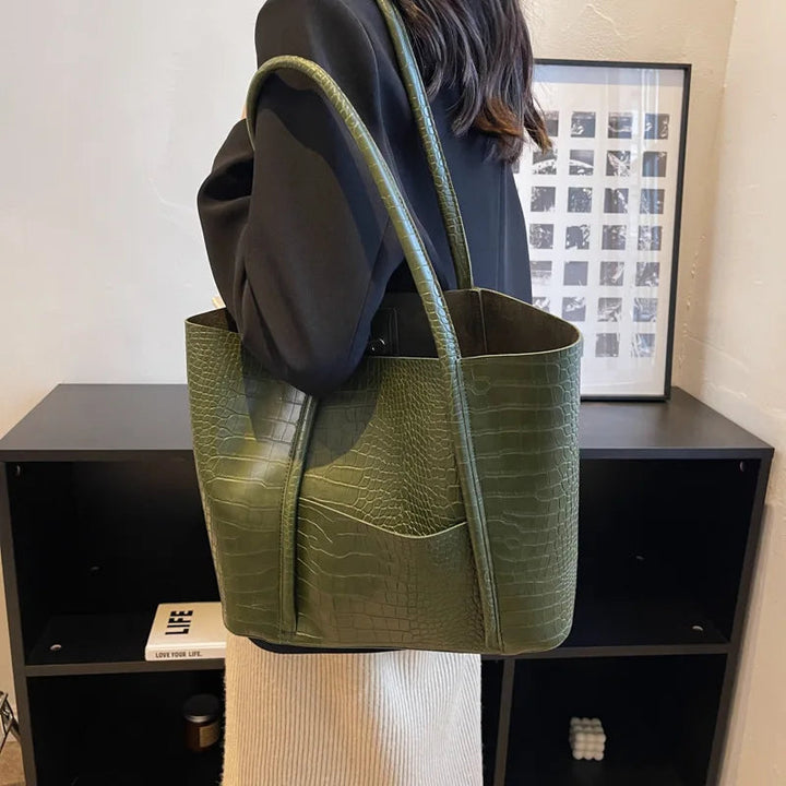A woman carrying an elegant shoulder bag with a rich finish over one shoulder