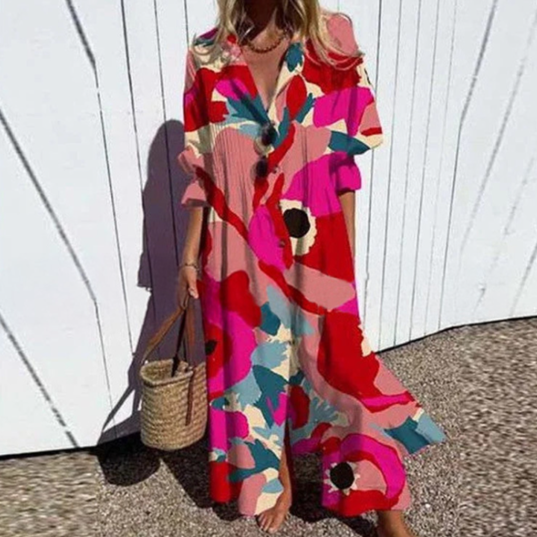 Woman wearing the Zara™ leaf print maxi dress with a button front, walking along the coast in a light breeze.