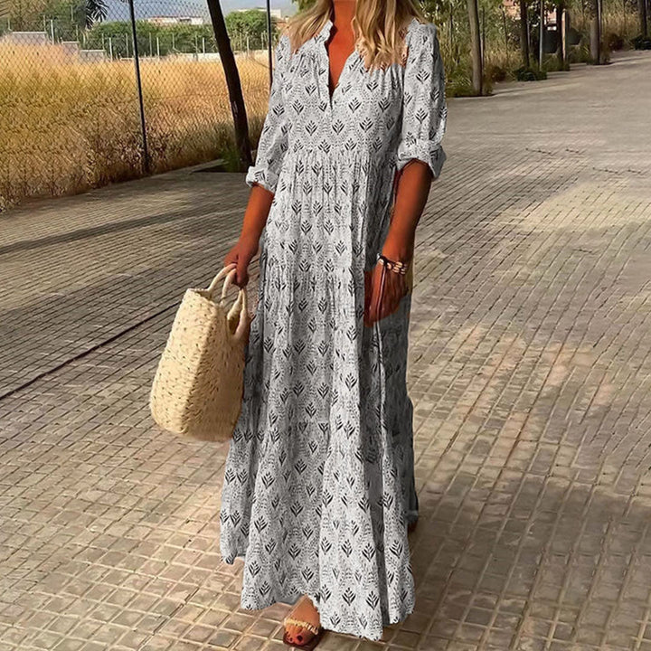 Woman wearing the Imelda™ elegant boho maxi dress with a V-neckline and flowing skirt at a summer occasion.