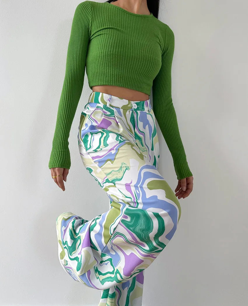 A woman wearing a bold abstract swirl-print shirt and matching wide-leg trousers in the city