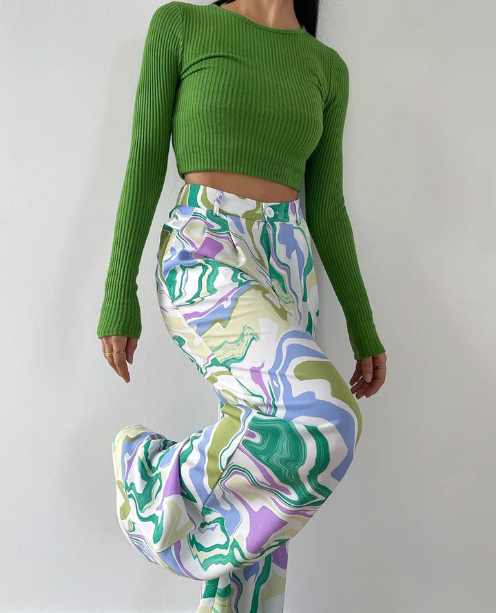 A woman wearing a bold abstract swirl-print shirt and matching wide-leg trousers in the city