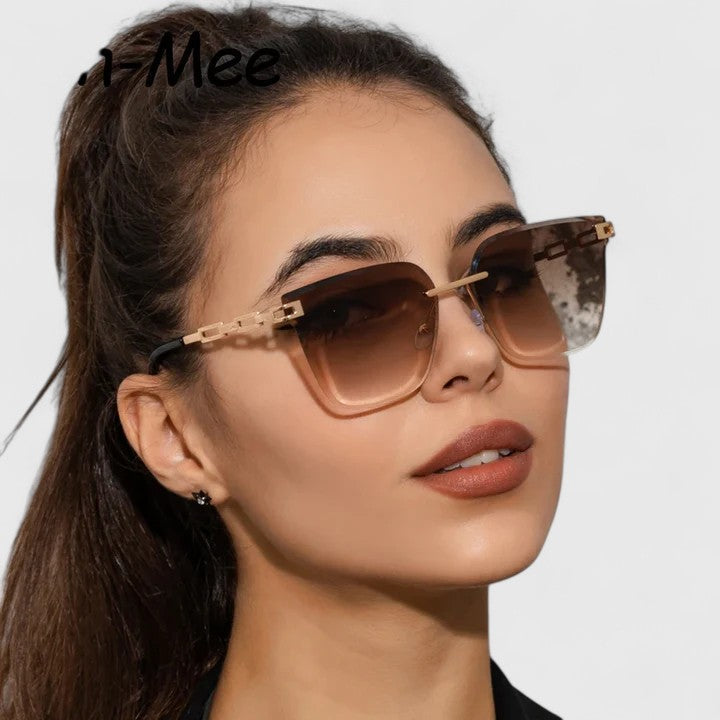 A woman wearing elegant cat-eye sunglasses with gradient lenses, glancing over her shoulder in the sun.