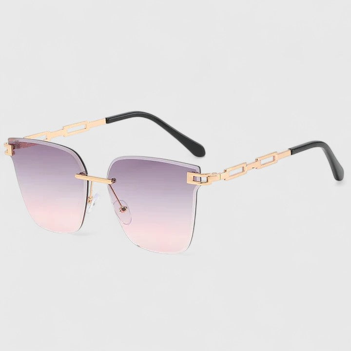 A woman wearing elegant cat-eye sunglasses with gradient lenses, glancing over her shoulder in the sun.
