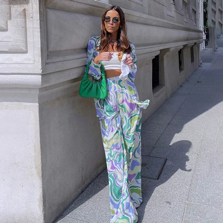 A woman wearing a bold abstract swirl-print shirt and matching wide-leg trousers in the city