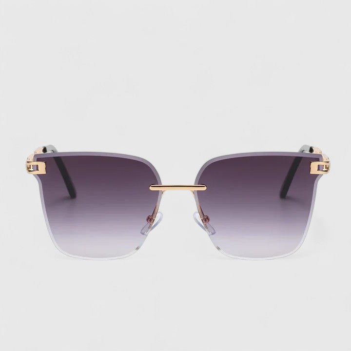 A woman wearing bold square sunglasses with brown gradient lenses and gold-tone chain-link arms.