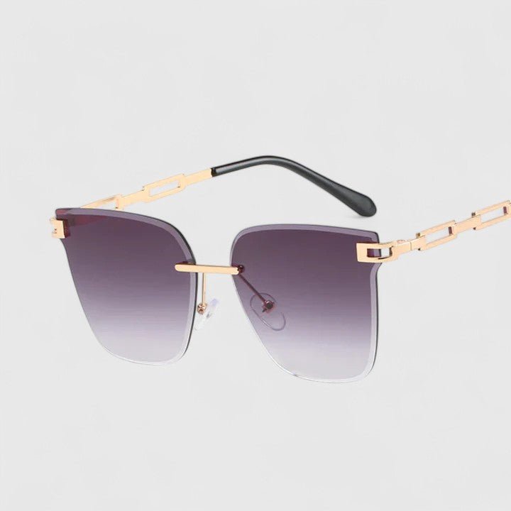 A woman wearing elegant cat-eye sunglasses with gradient lenses, glancing over her shoulder in the sun.