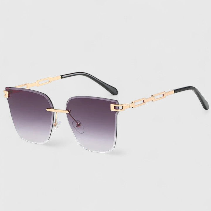 A woman wearing elegant cat-eye sunglasses with gradient lenses, glancing over her shoulder in the sun.
