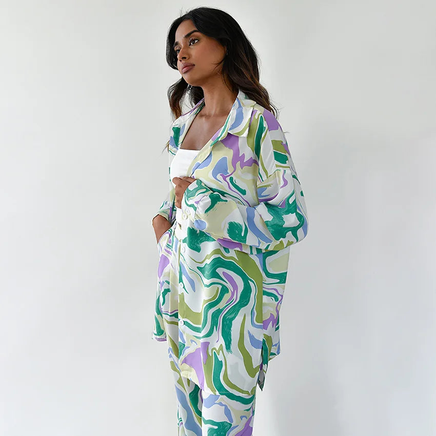 A woman wearing a bold abstract swirl-print shirt and matching wide-leg trousers in the city