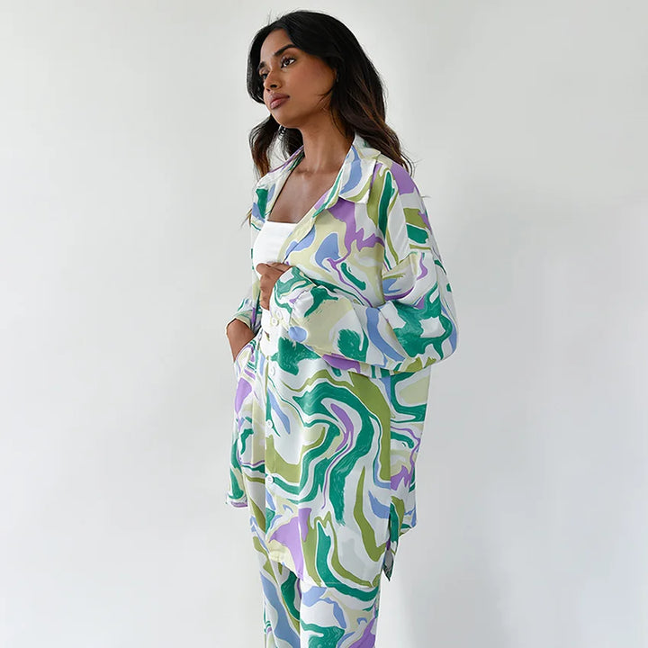 A woman wearing a bold abstract swirl-print shirt and matching wide-leg trousers in the city