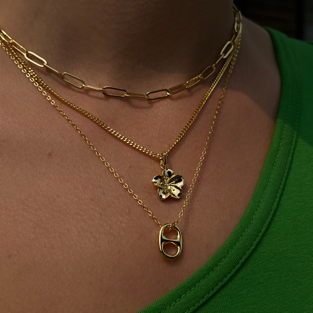 Hibiscus flower pendant necklace in gold tone on a white background