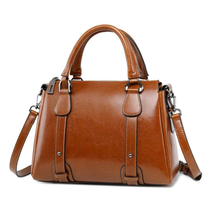A woman with a polished structured shoulder bag resting at her hip while out for the day.