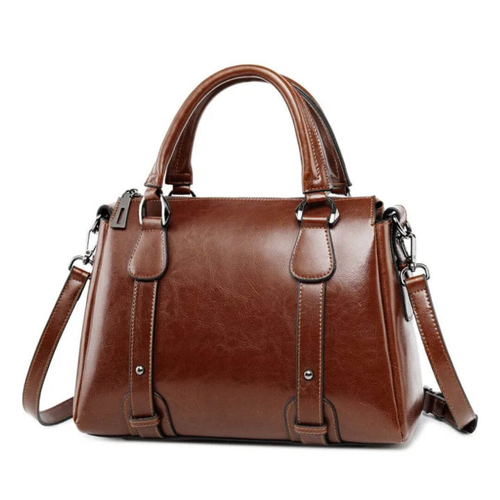 A woman with a polished structured shoulder bag resting at her hip while out for the day.