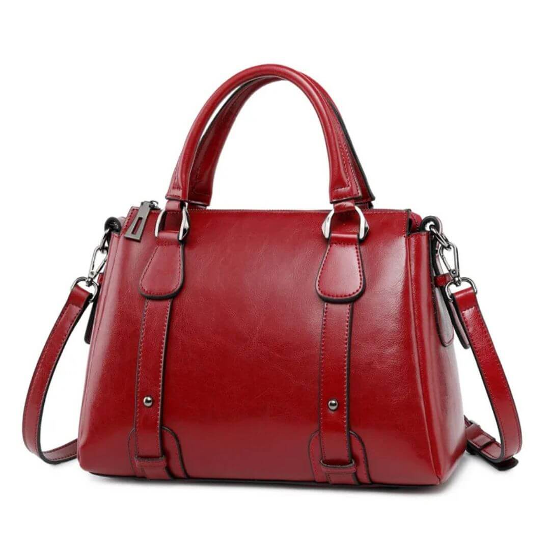 A woman with a polished structured shoulder bag resting at her hip while out for the day.
