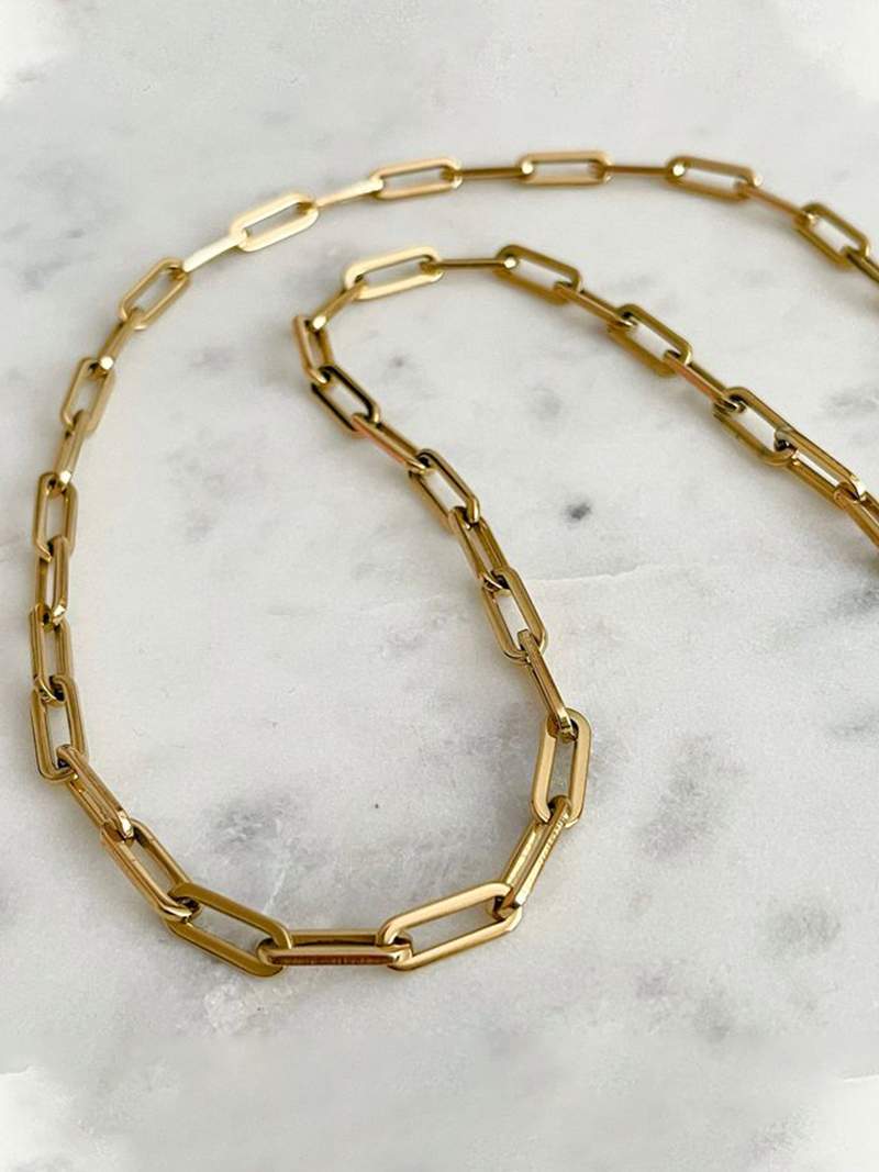 Gold-plated bicycle charm pendant necklace on a white background