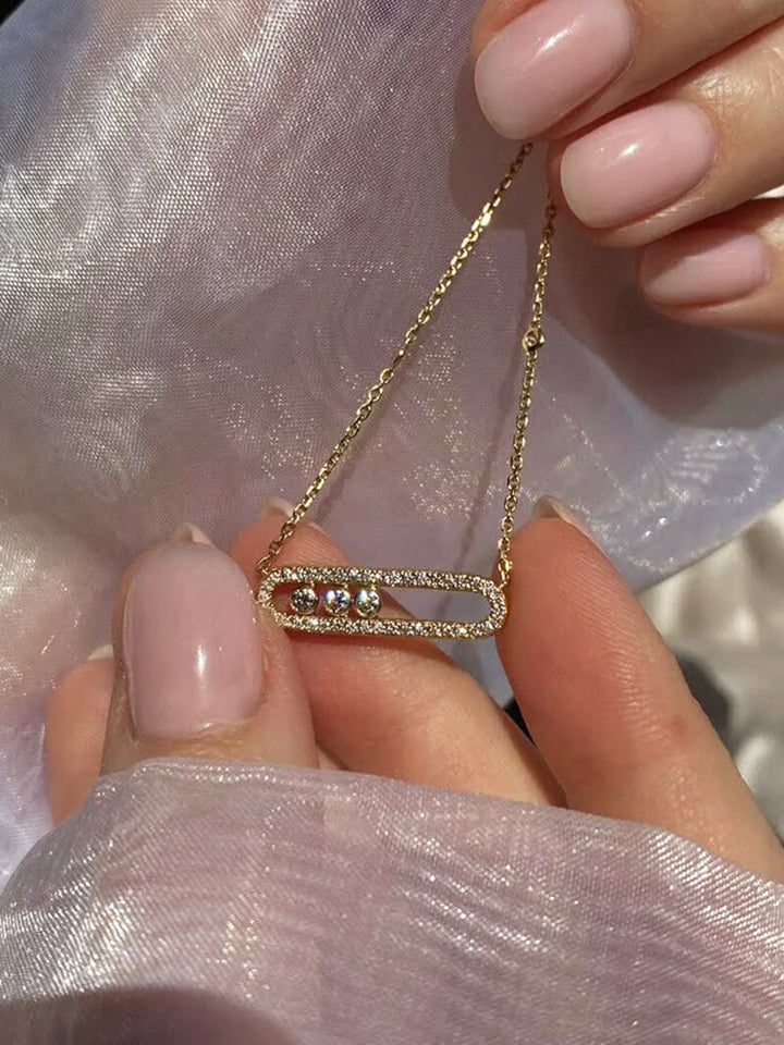 Delicate pendant necklace with three dancing diamond stones in yellow gold finish