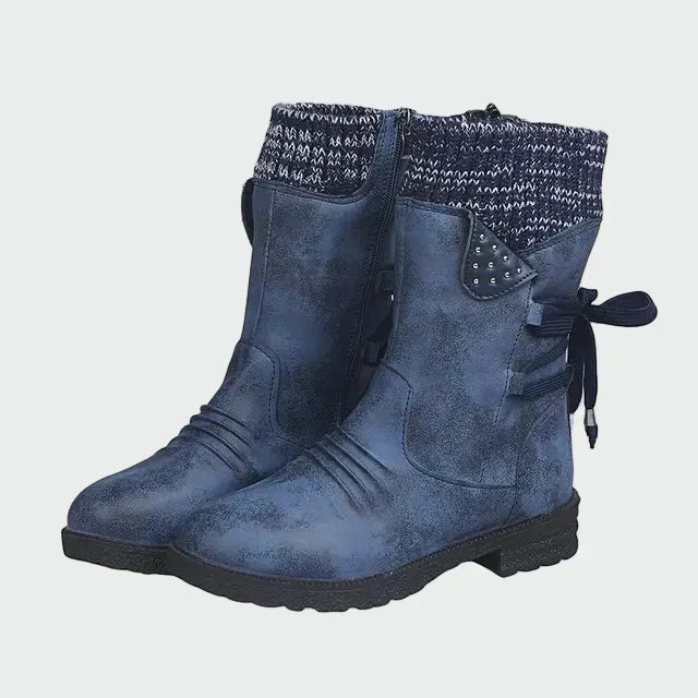 Woman wearing blue urban ankle boots with jeans on a winter city street.