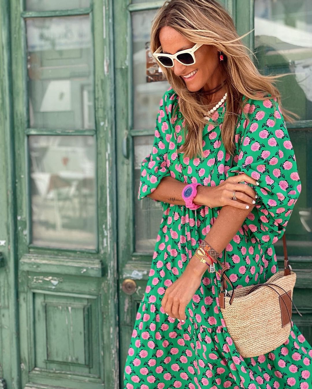 A woman wearing the Concepta spring print dress in green and pink tones, styled for a day out.