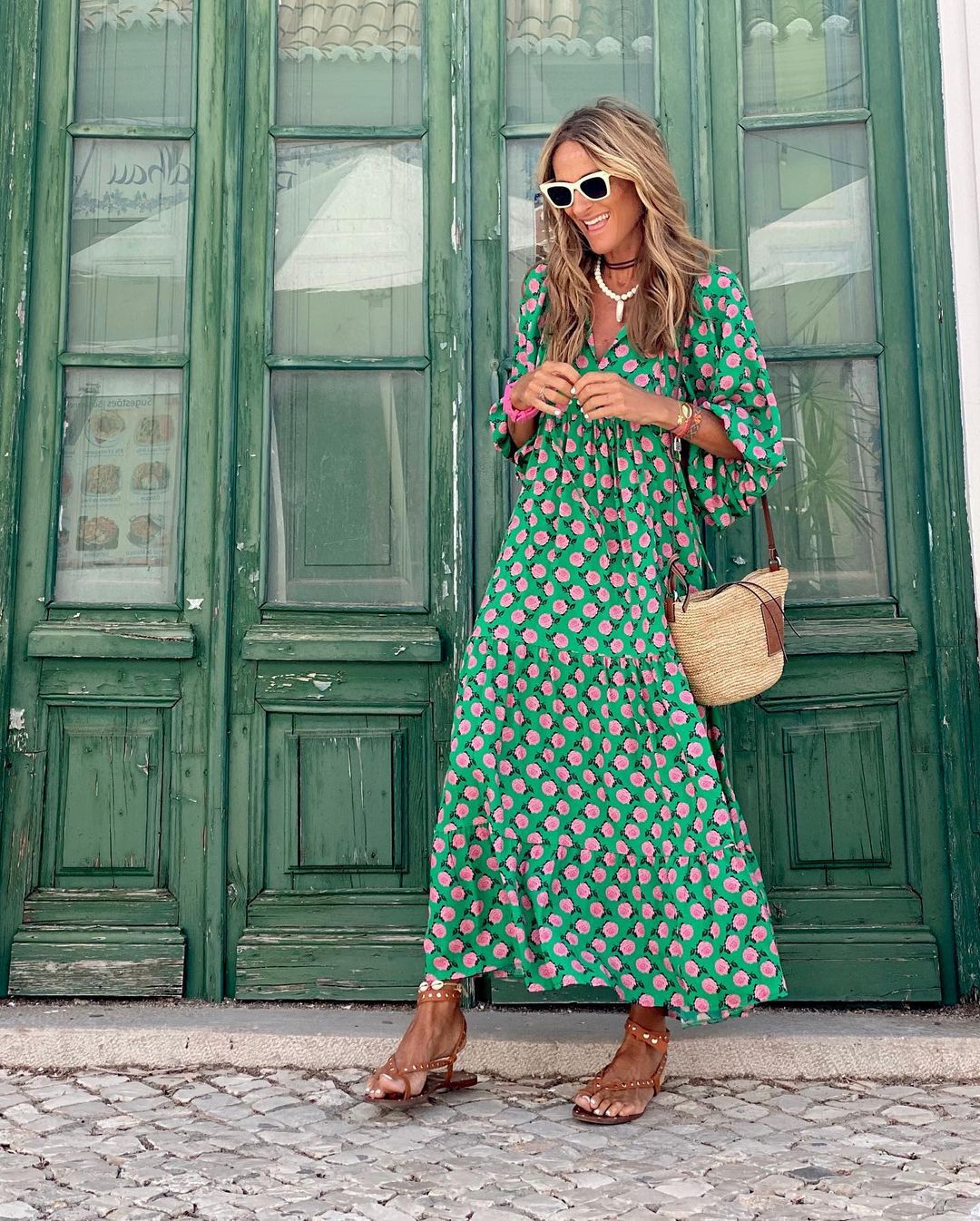 A woman wearing the Concepta spring print dress in green and pink tones, styled for a day out.