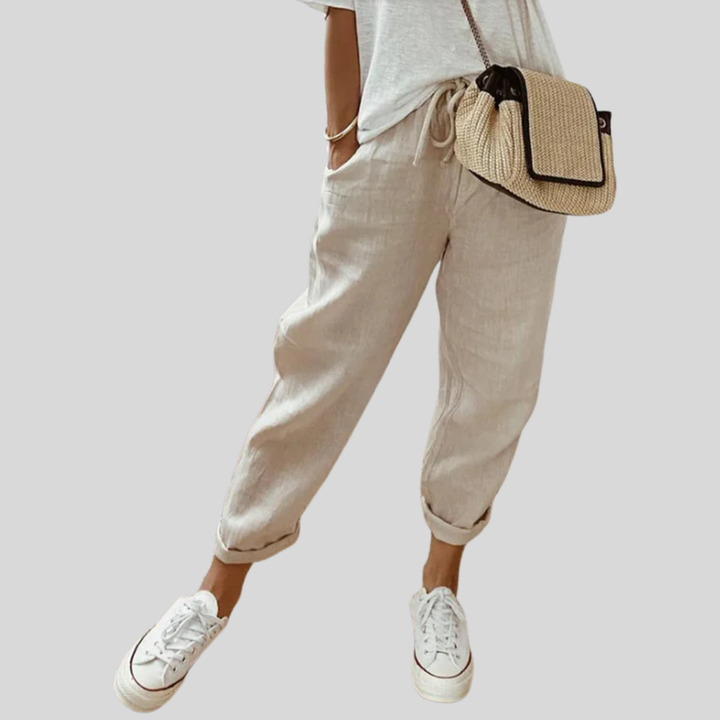 A woman wearing flowing elegant trousers with a soft elastic waist and deep pockets.