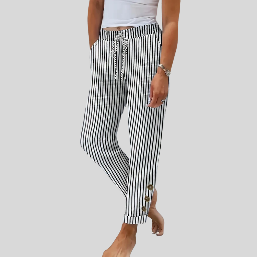 A woman wearing black vertical-striped trousers with a drawstring waist and button hem detail.