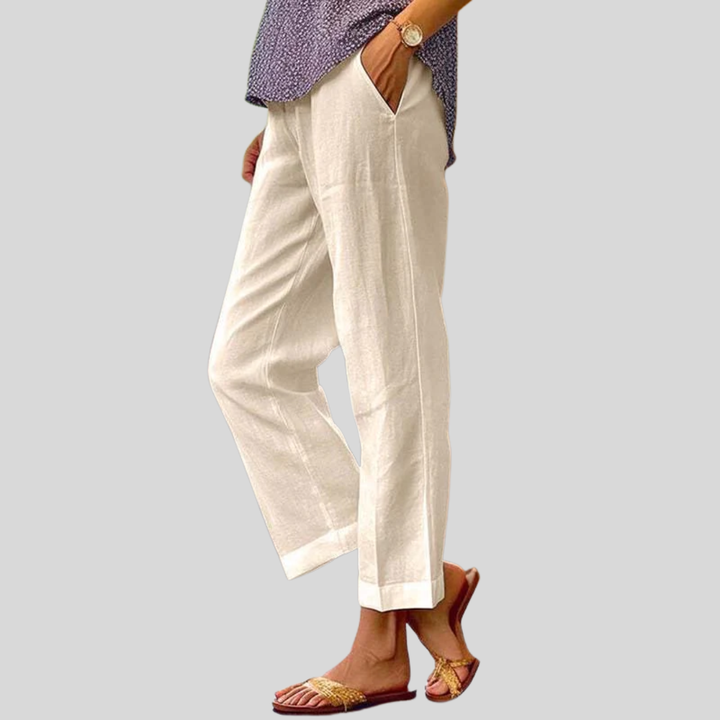 Woman wearing relaxed straight-leg trousers with a soft top, standing in soft daylight.