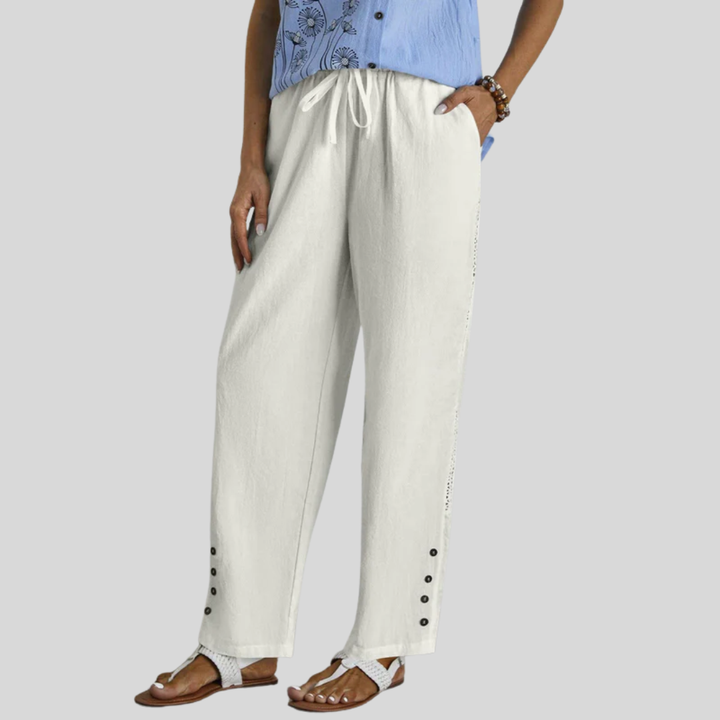 Woman wearing relaxed button-detail trousers with a simple top, out for the day.