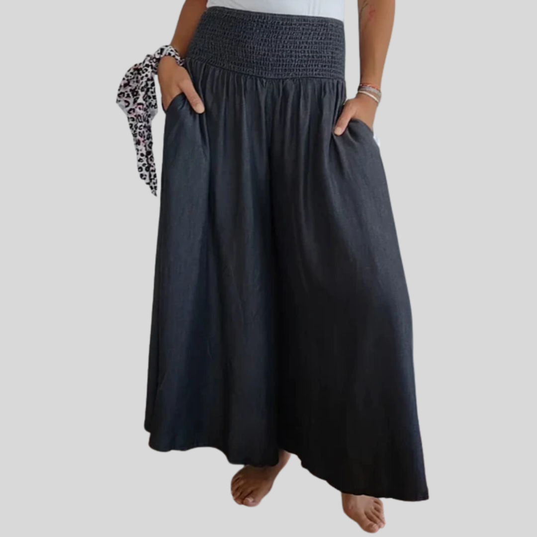 Woman wearing high-waist wide-leg trousers with a tucked-in blouse, mid-stride.