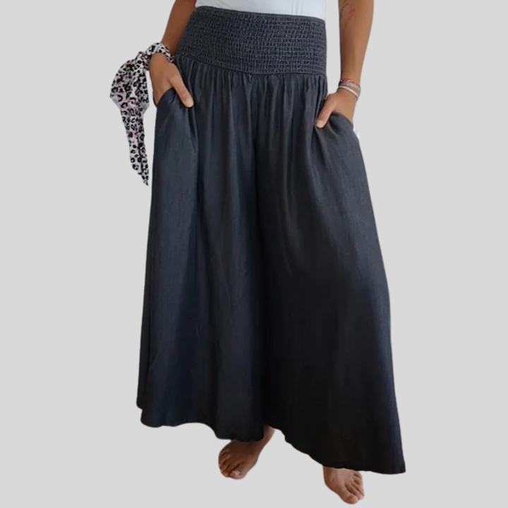 Woman wearing high-waist wide-leg trousers with a tucked-in blouse, mid-stride.