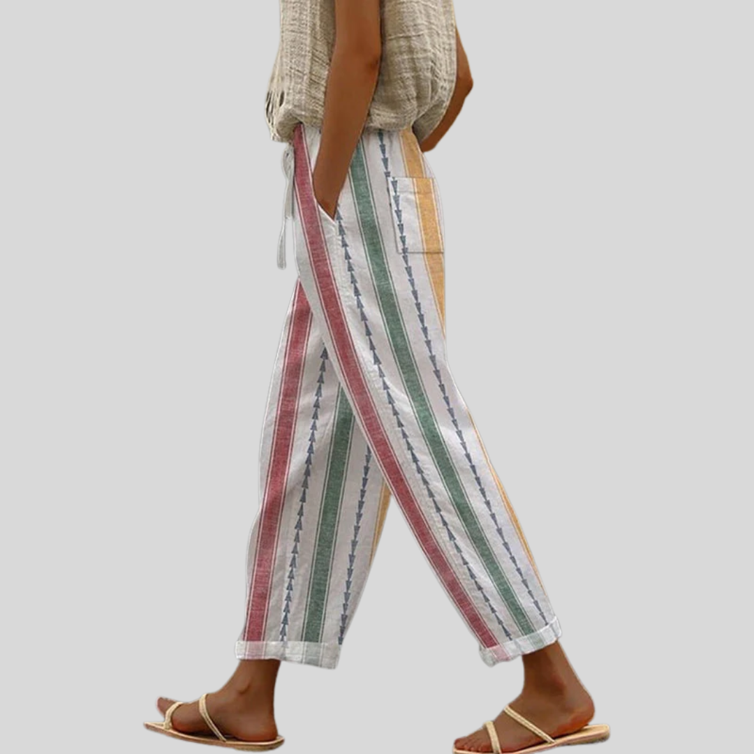 A woman wearing colourful vertical-striped casual trousers with a straight leg and elastic waist.