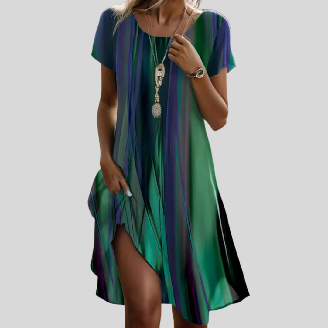 Woman wearing the Ita™ multicoloured gradient boho midi dress, walking outdoors with the skirt flowing around her.