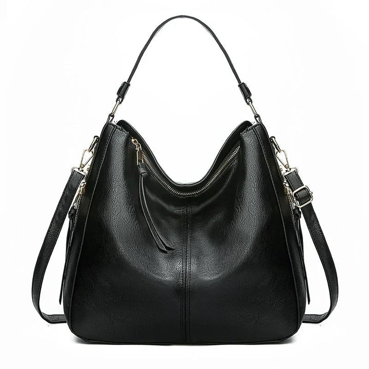 A woman holding a timeless classic handbag with a rich finish by her side