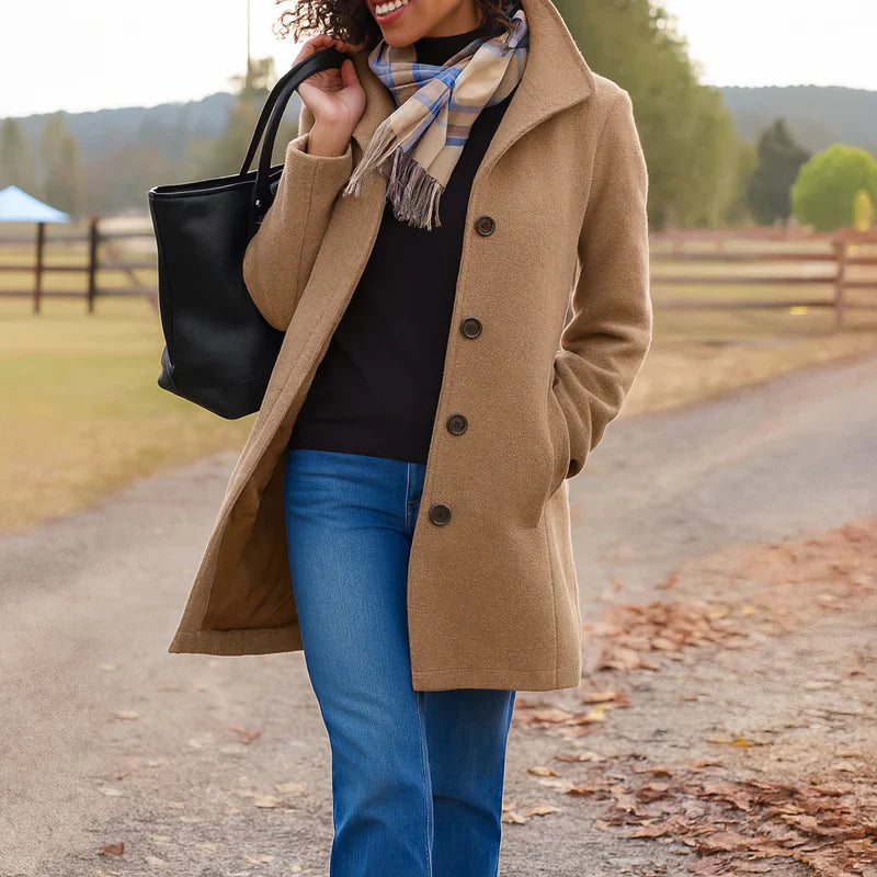 A woman wearing an elegant single-button coat over a jumper on a crisp autumn day.