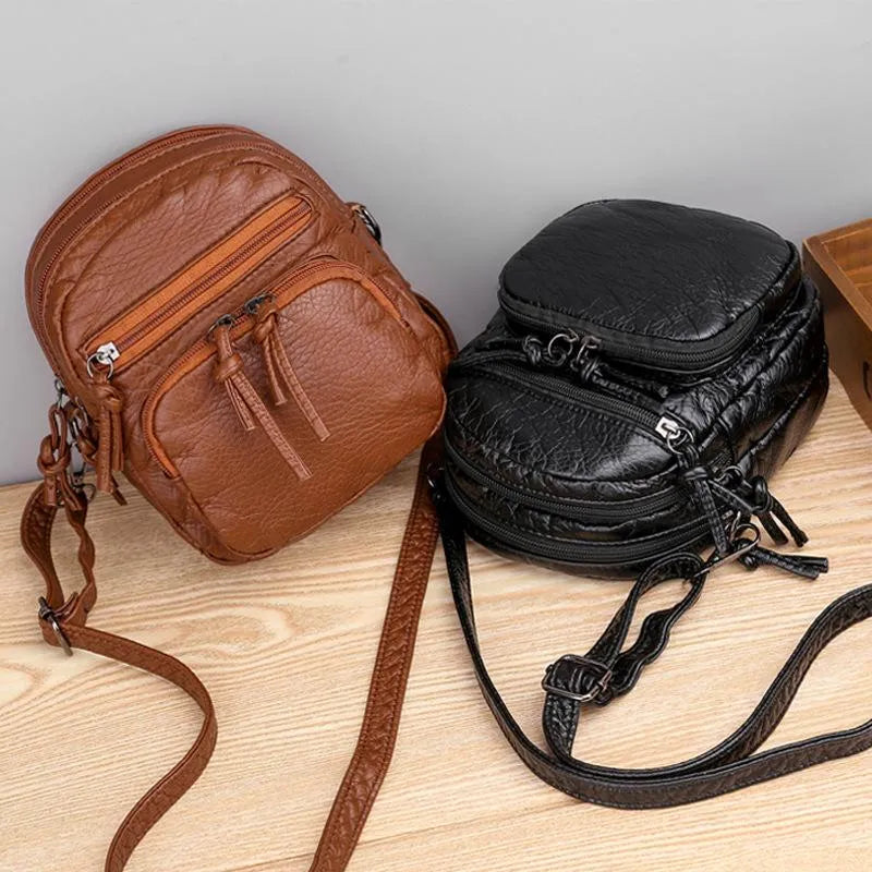 A woman carrying a simple black everyday handbag on her shoulder on a relaxed day out.